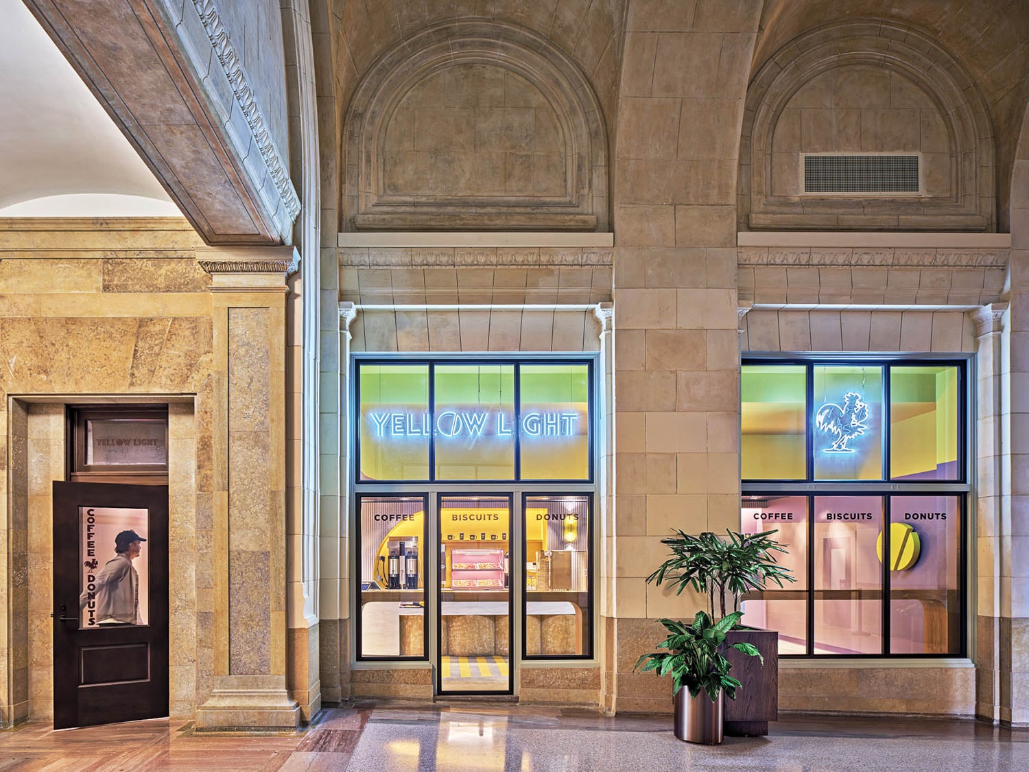 A stylish café entrance in an elegant building featuring large windows