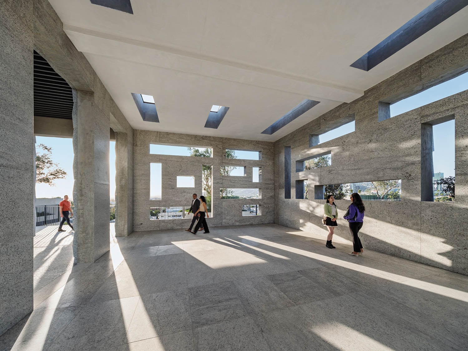 Modern pavilion with rectangular openings in concrete walls, creating abstract patterns