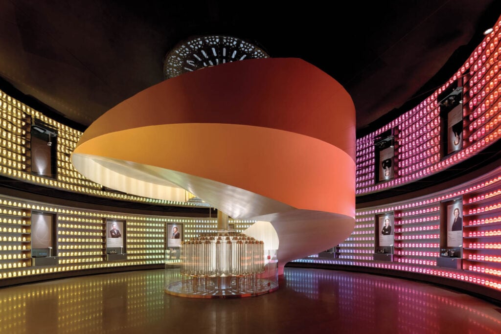 Futuristic room with a central, spiral staircase in warm orange hues