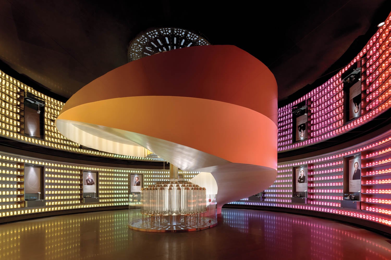 Futuristic room with a central, spiral staircase in warm orange hues