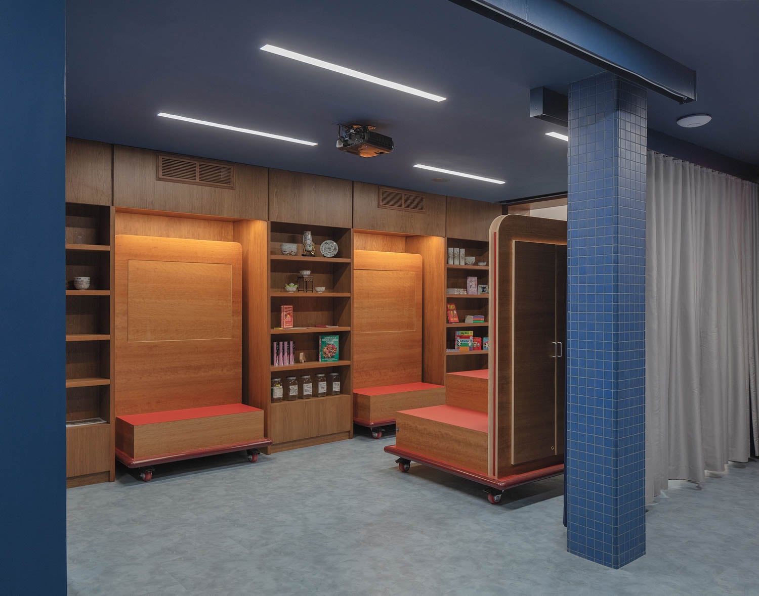 Modern room with blue walls and ceiling, featuring wooden shelves with books and items