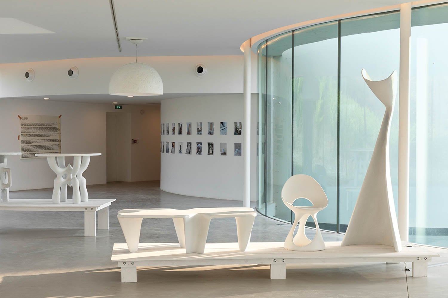 Modern art gallery with sleek, abstract white sculptures on minimalist platforms