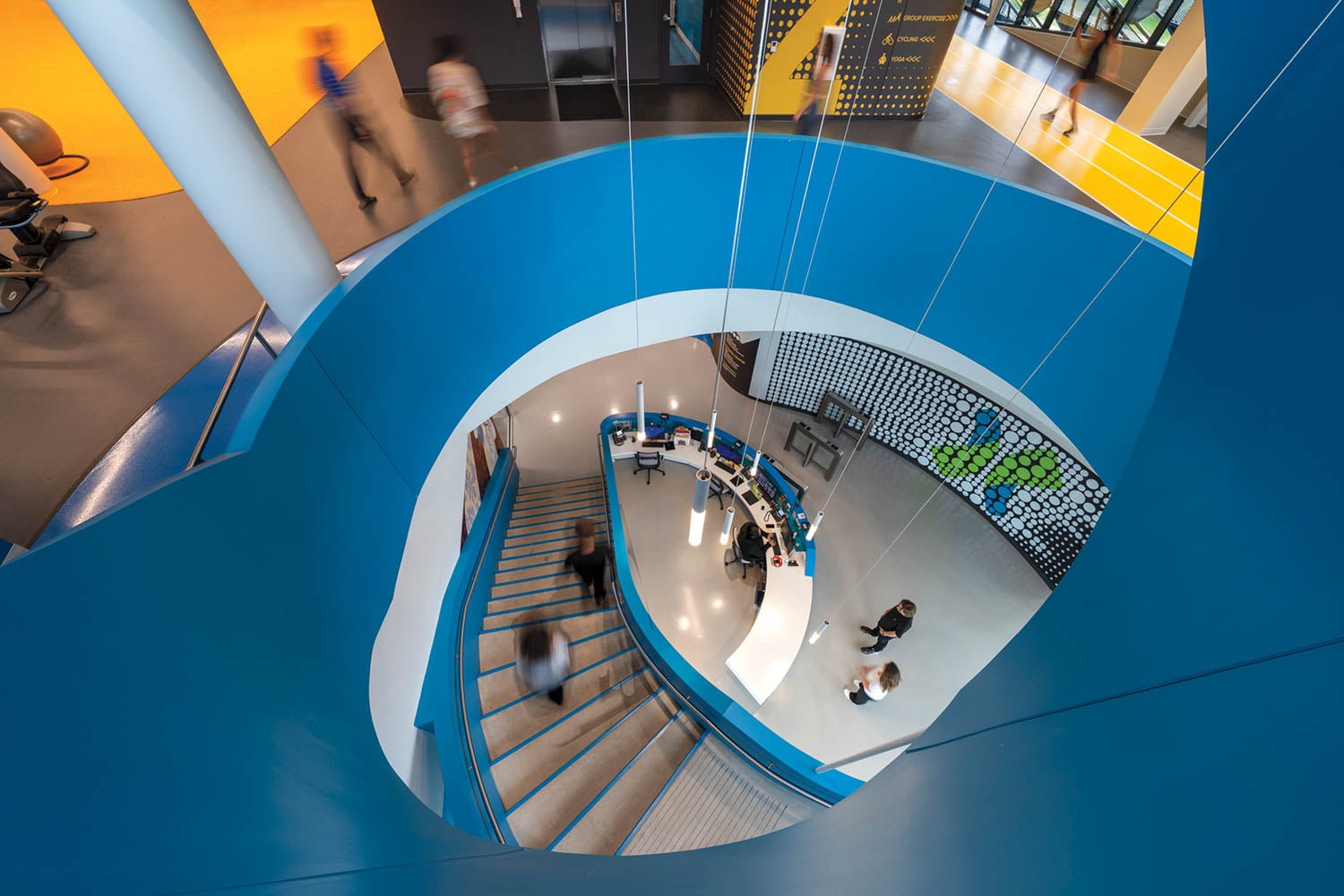 Overhead view of a vibrant, modern spiral staircase with blue railings
