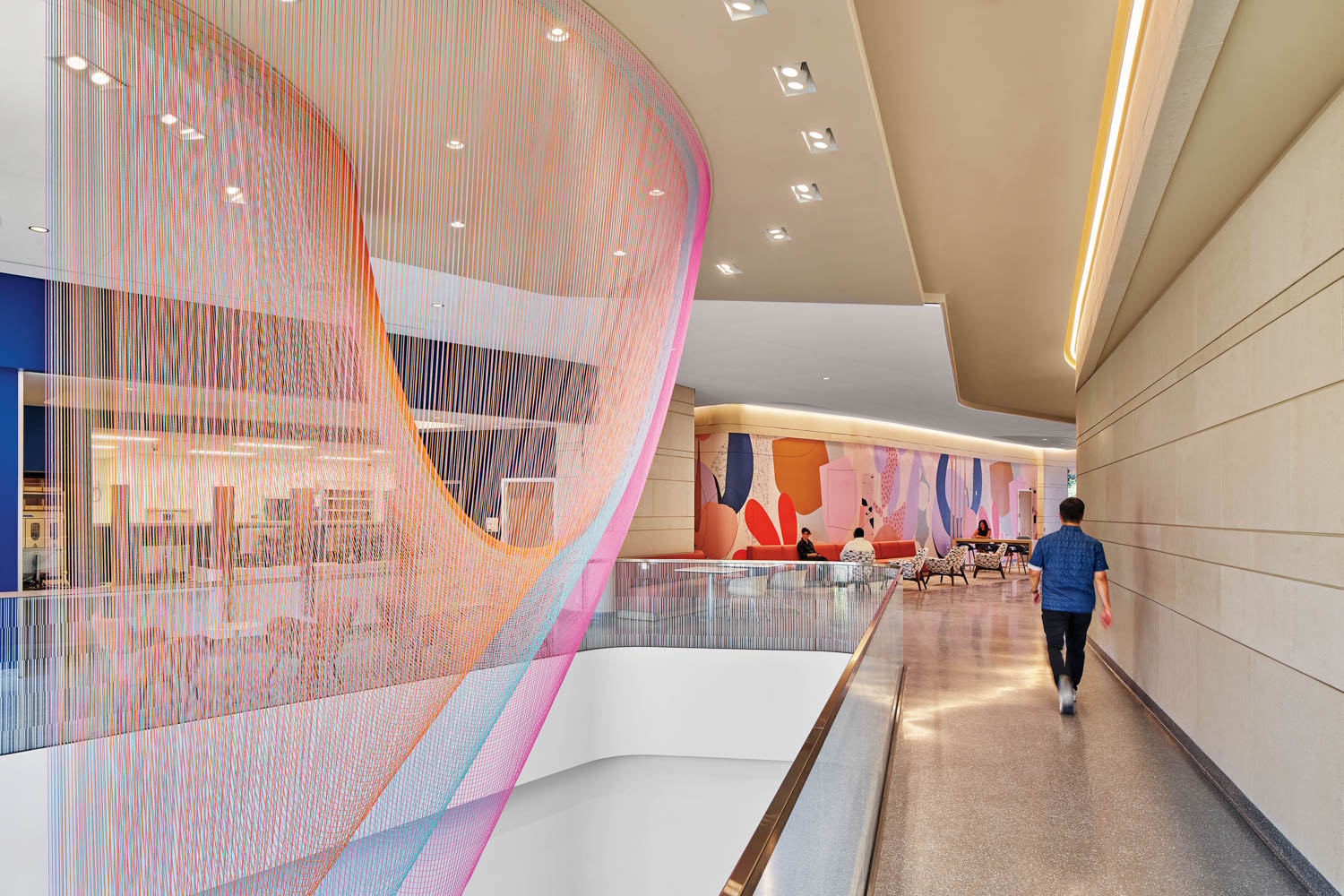 Modern hallway with vibrant, multicolored string art installation and abstract wall mural