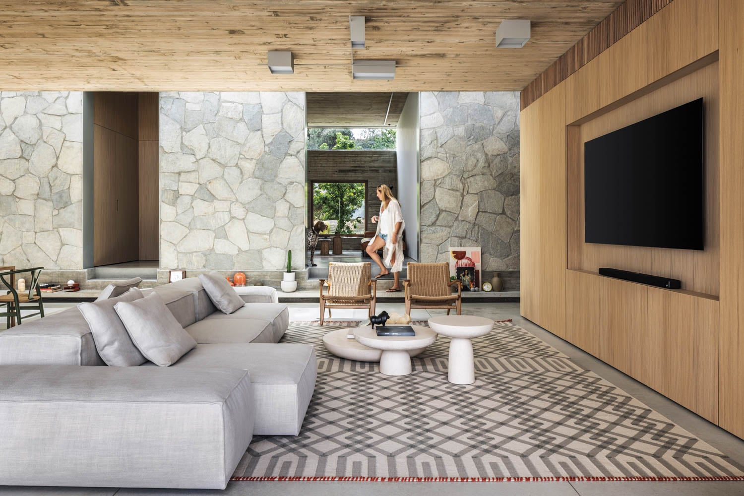 Spacious modern living room with stone walls and wood accents