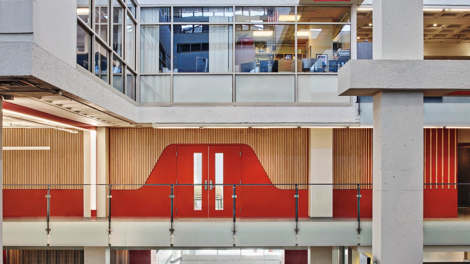 Modern interior with glass walls and red accents, featuring a geometric design