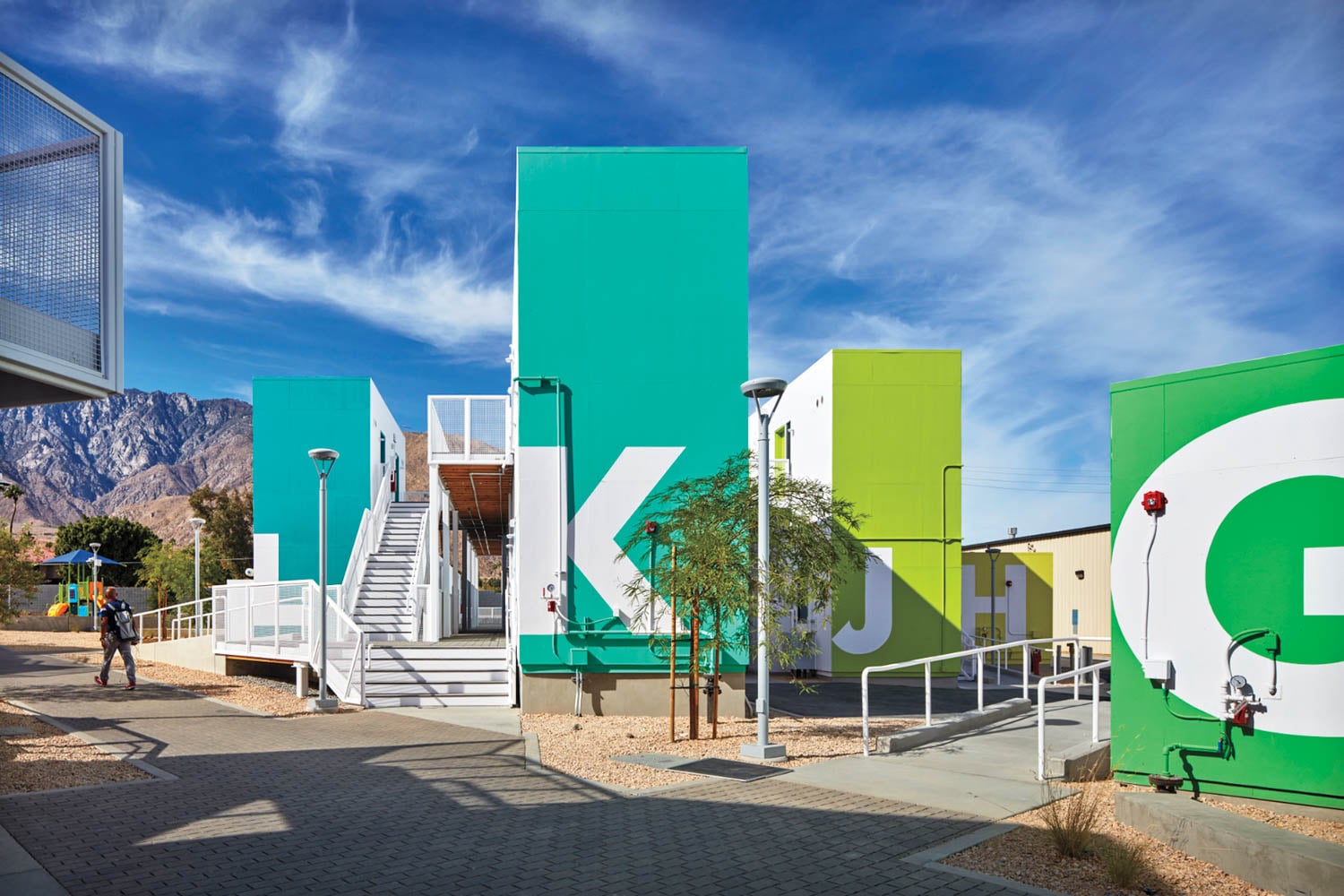 Bright, modern school buildings with large letters and bold colors under a blue sky