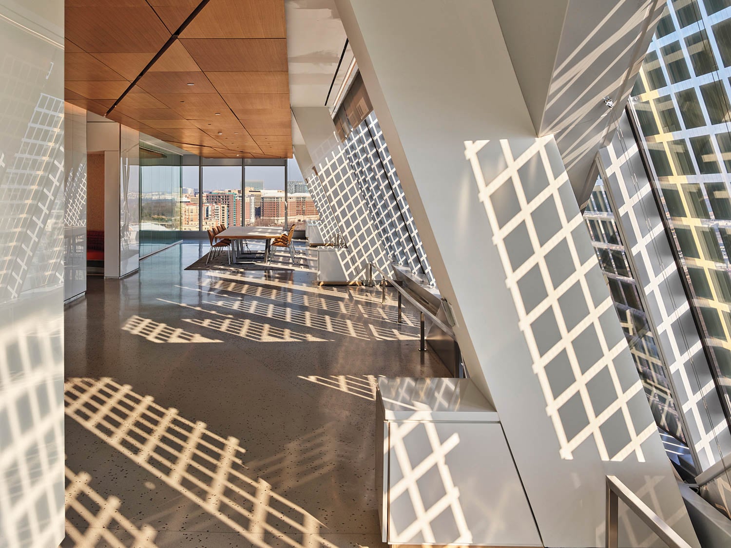 Modern room with large windows casting grid-like shadows on the floor