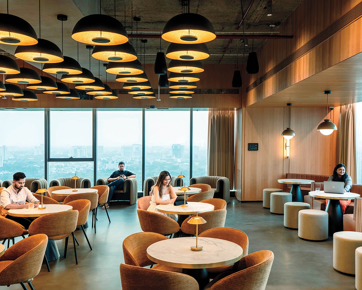 Modern lounge with circular tables, cozy chairs, and warm lighting