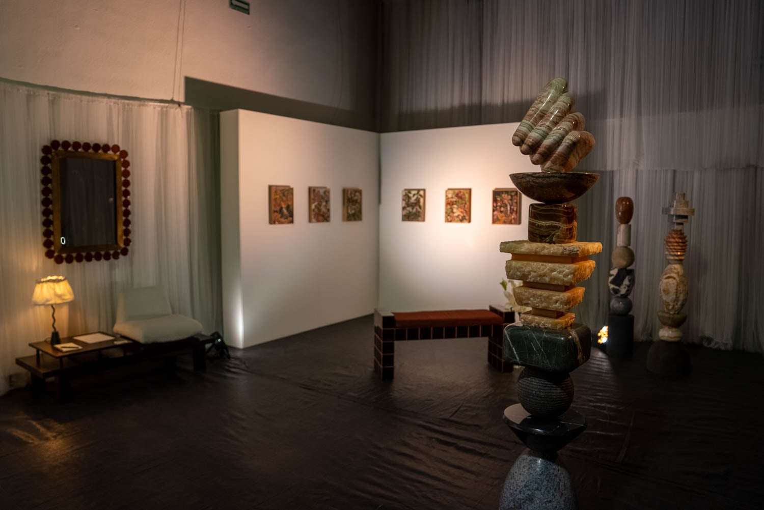 Dimly lit art gallery with stone sculptures and wall paintings