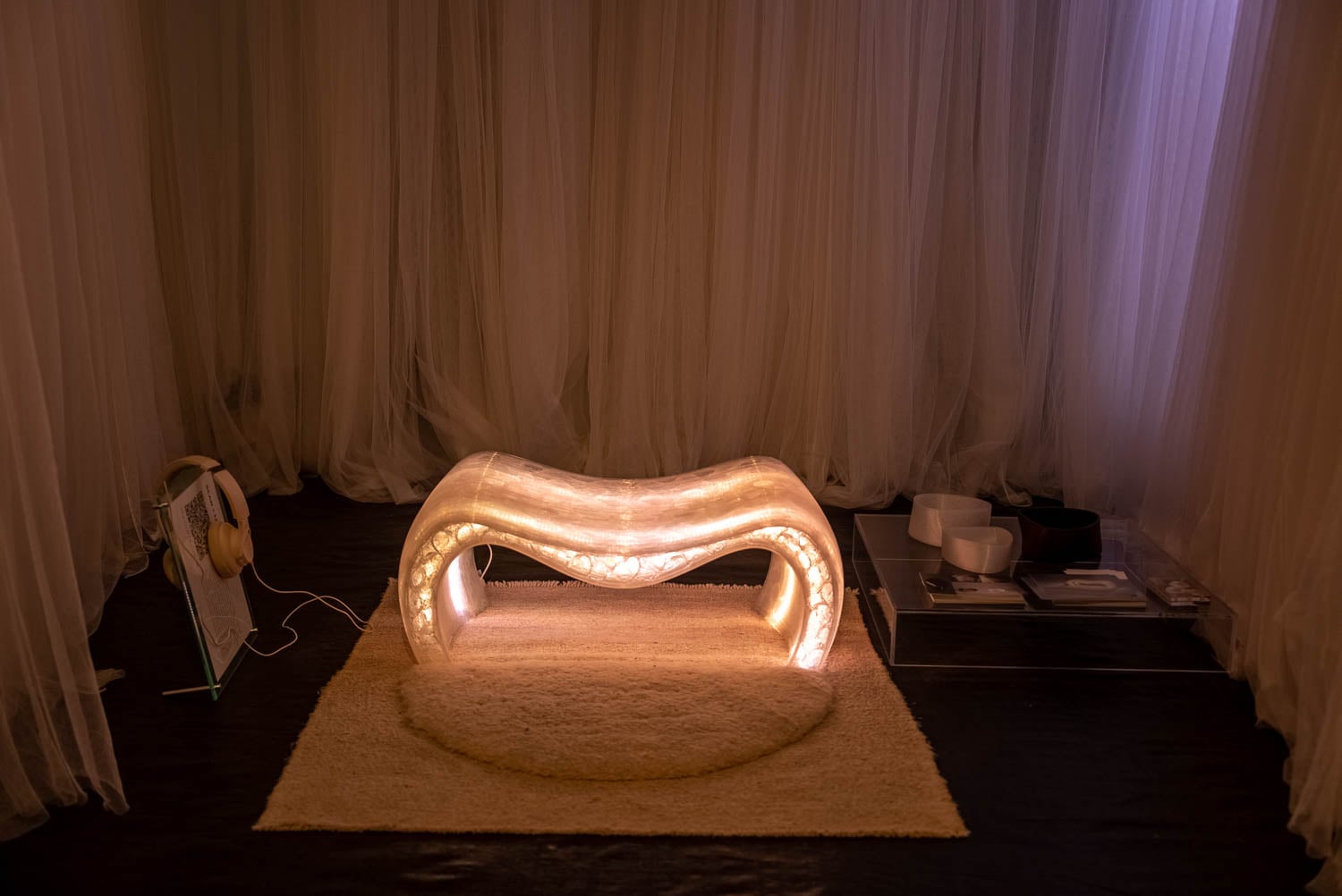 Illuminated sculptural seat forms the focus of a dimly lit room