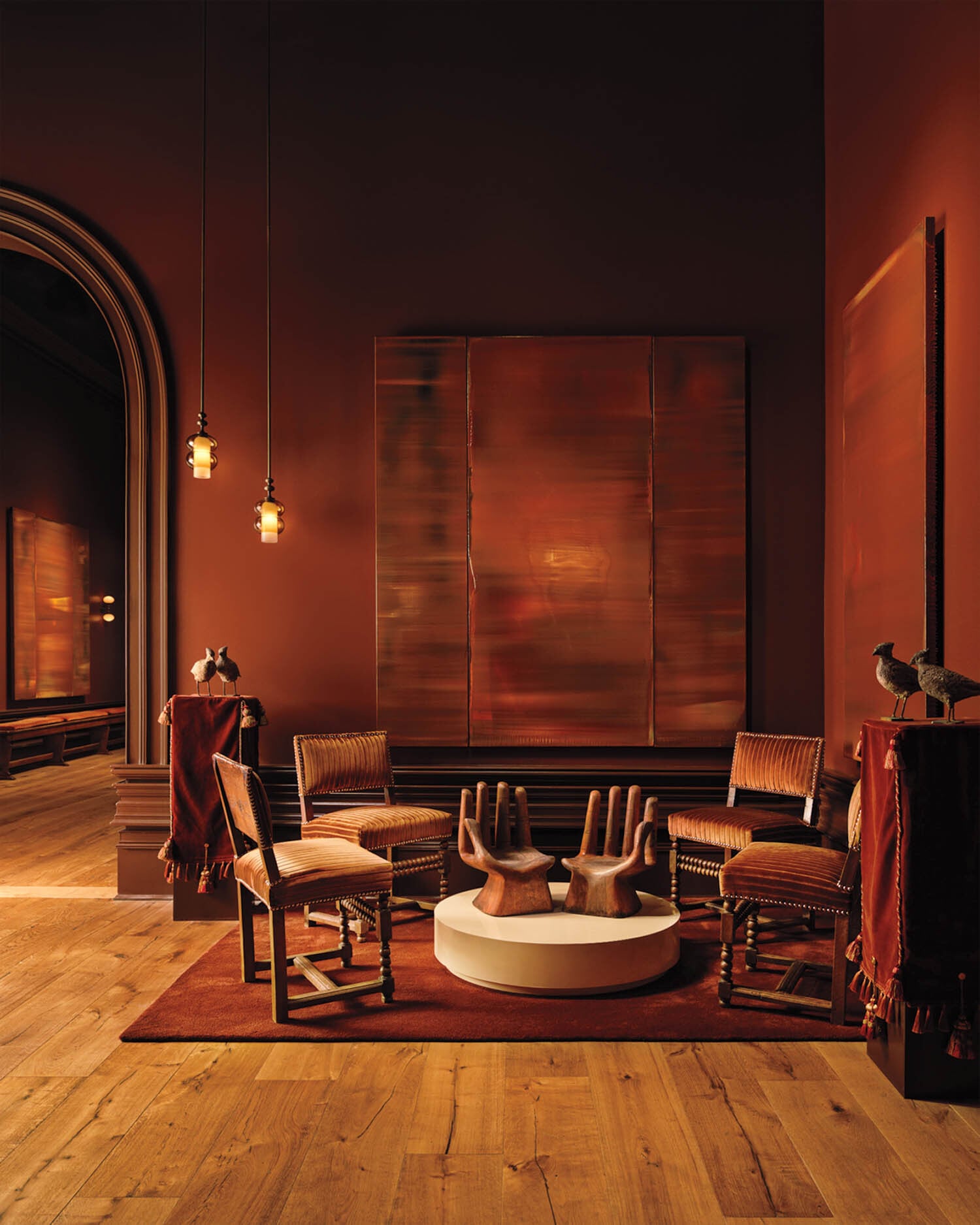 a wood paneled room with wooden hands as centerpiece on pedestal