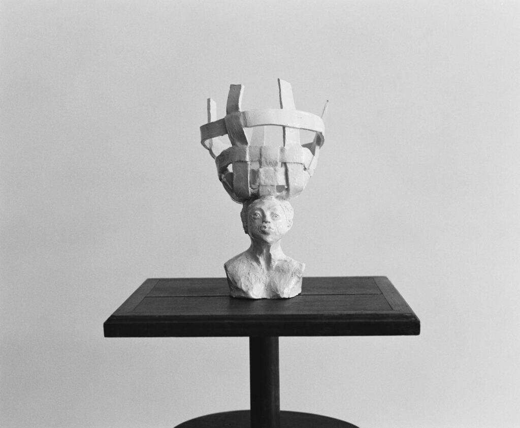 clay sculpture of person with crown