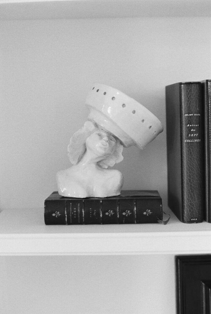 clay sculpture on bookshelf