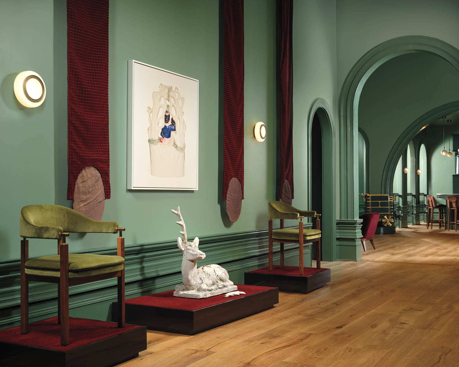 green hallway with green chairs and reindeer sculpture