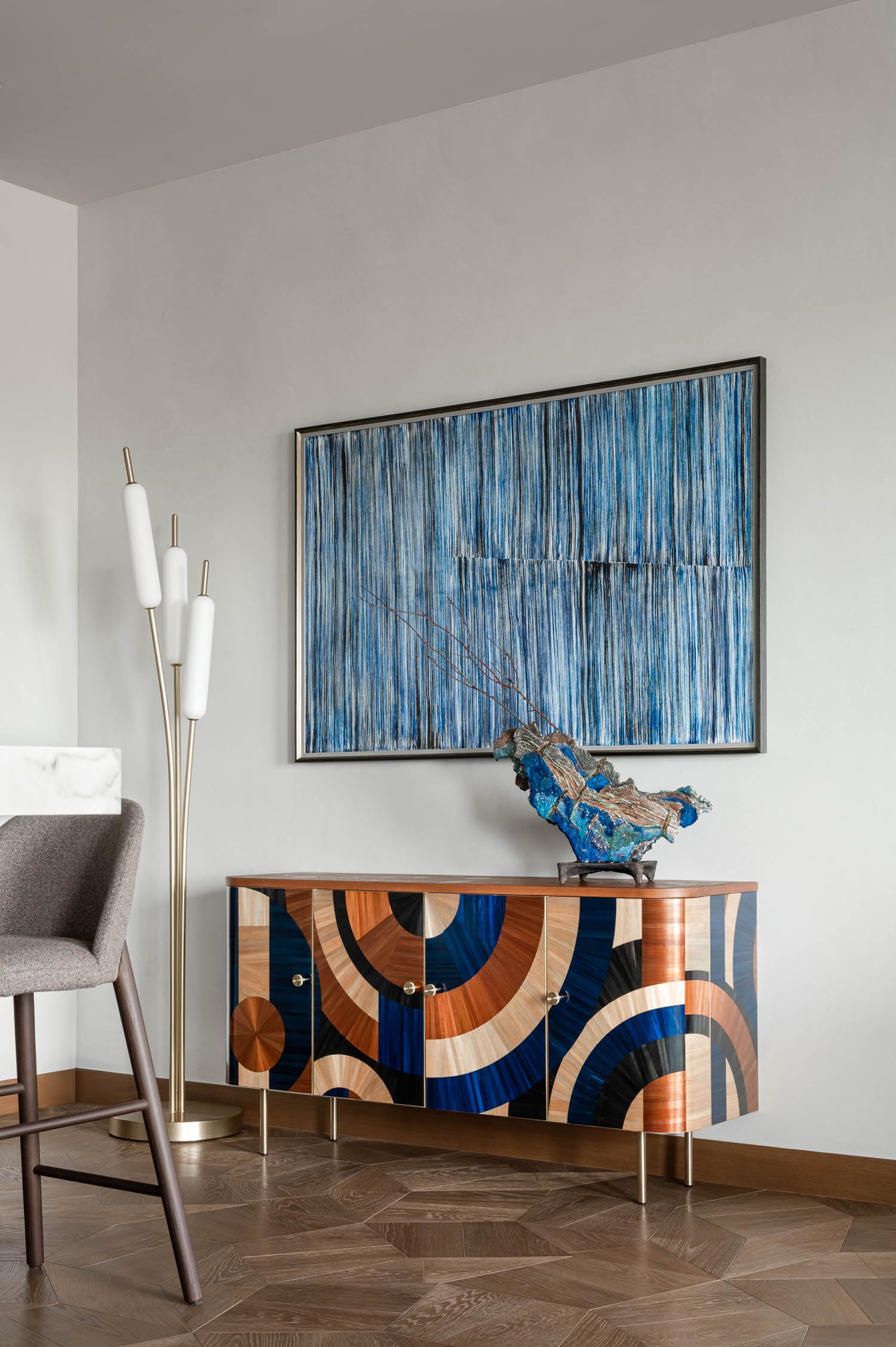 blue art piece hanging above a colorful console