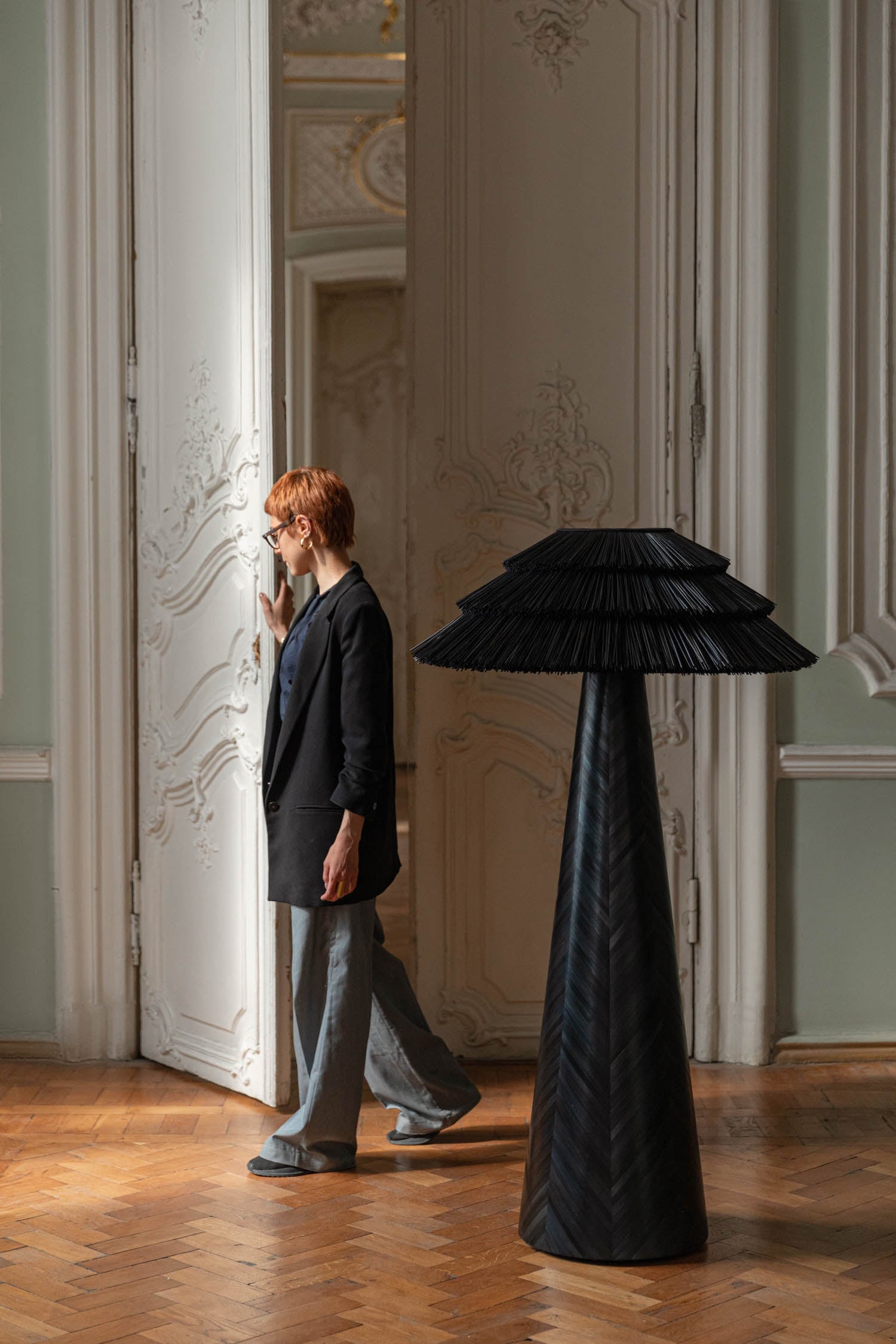 person walking by tall black lamp