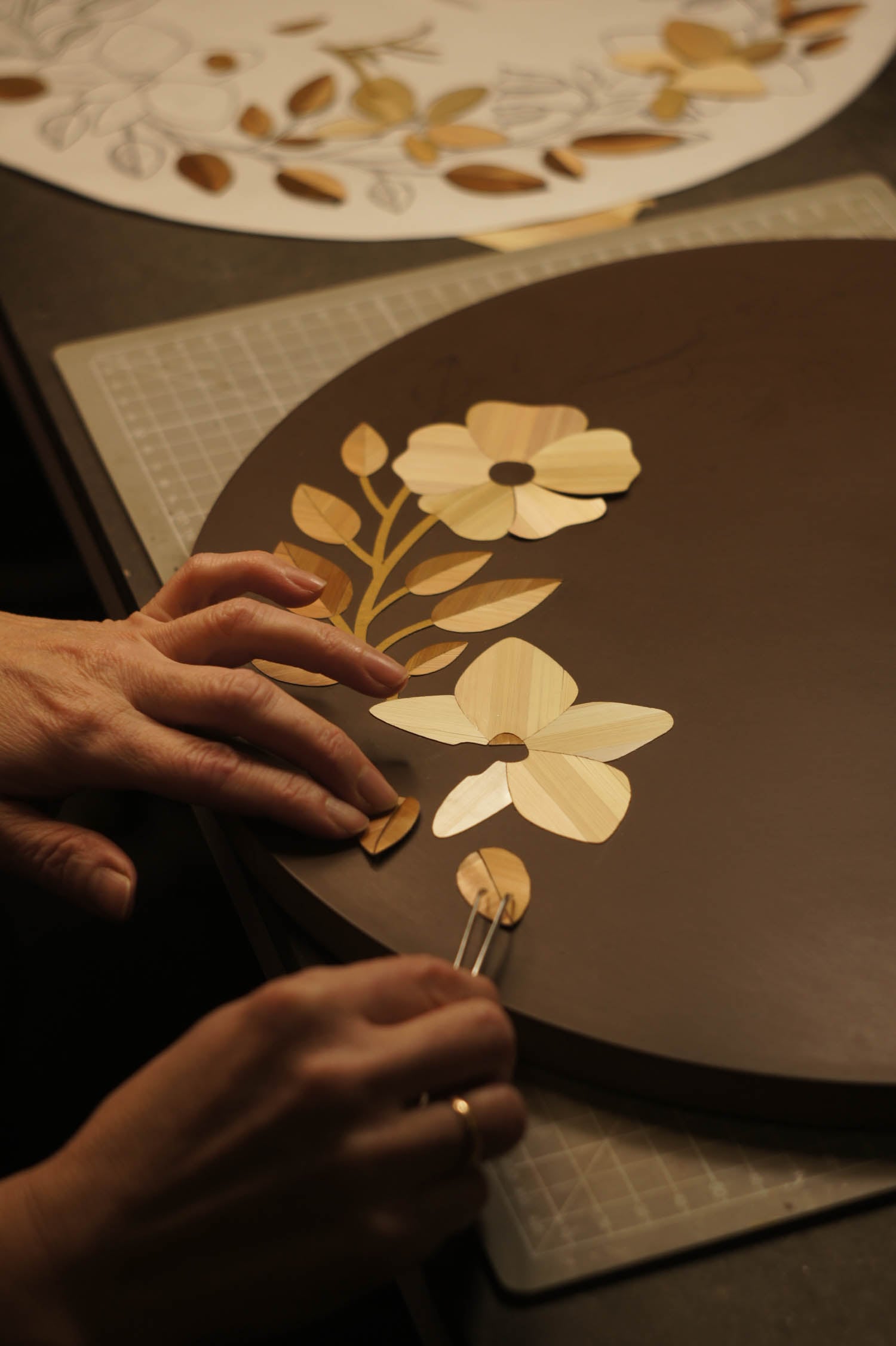 hands putting together petals on a tray
