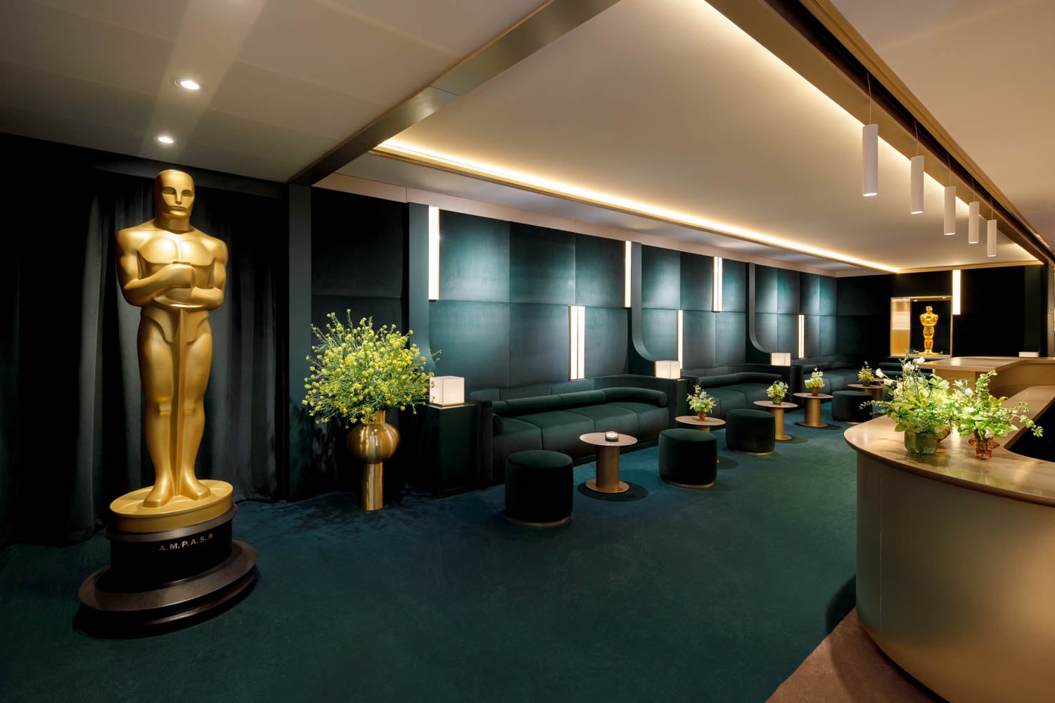 A lavish, dimly lit lounge showcases a large golden statue on the left at the Oscars 2026