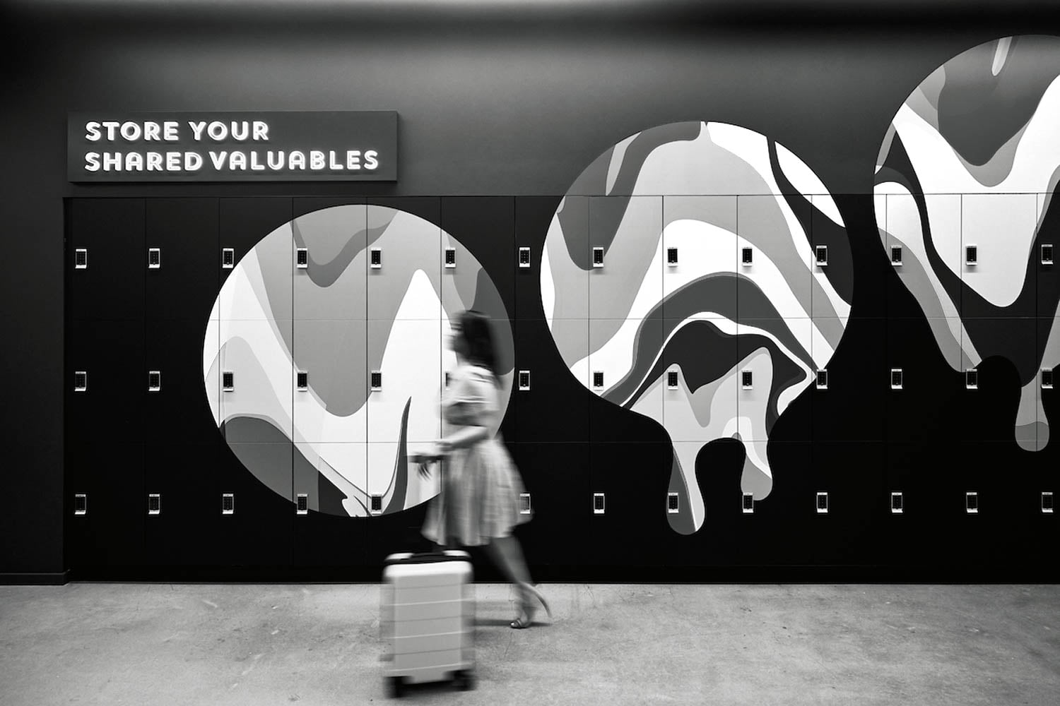 woman walking past lockers with circular emblems