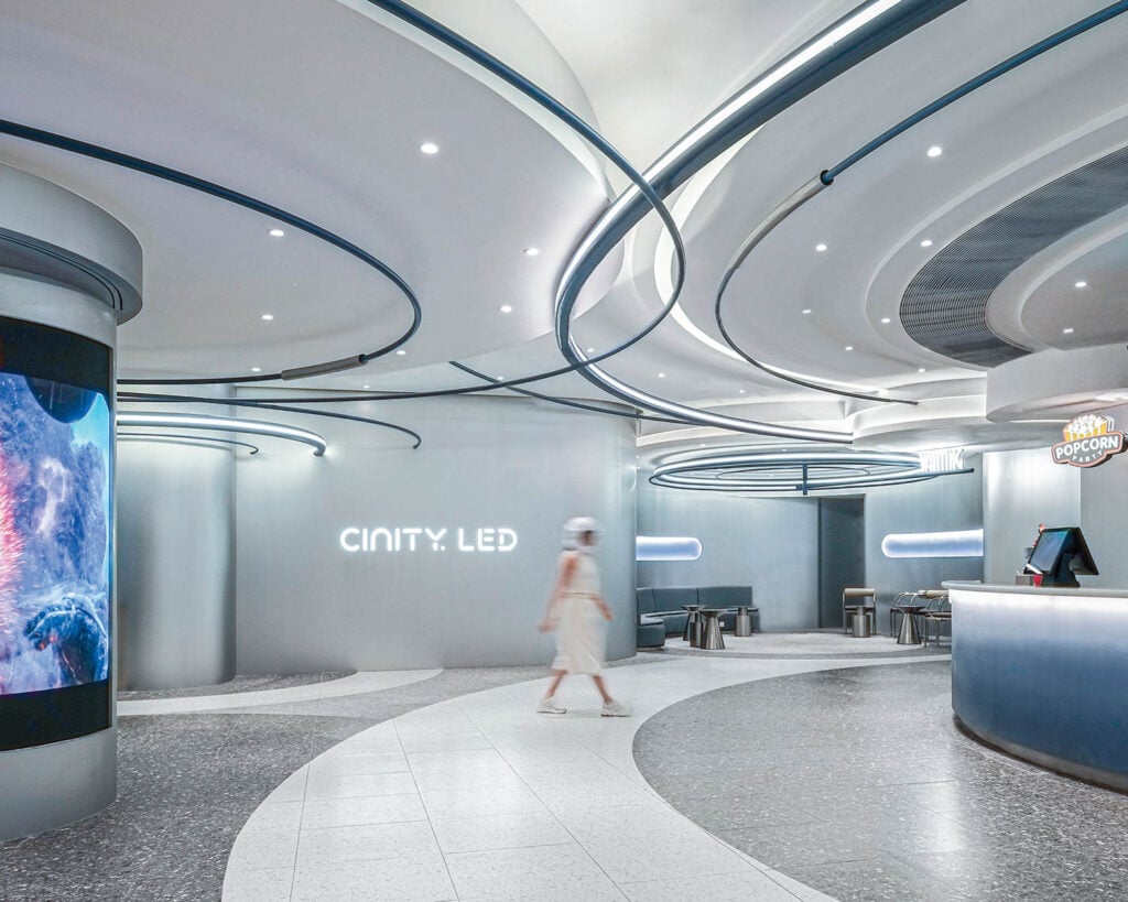 Futuristic cinema lobby with sleek curves, soft lighting, and a modern design