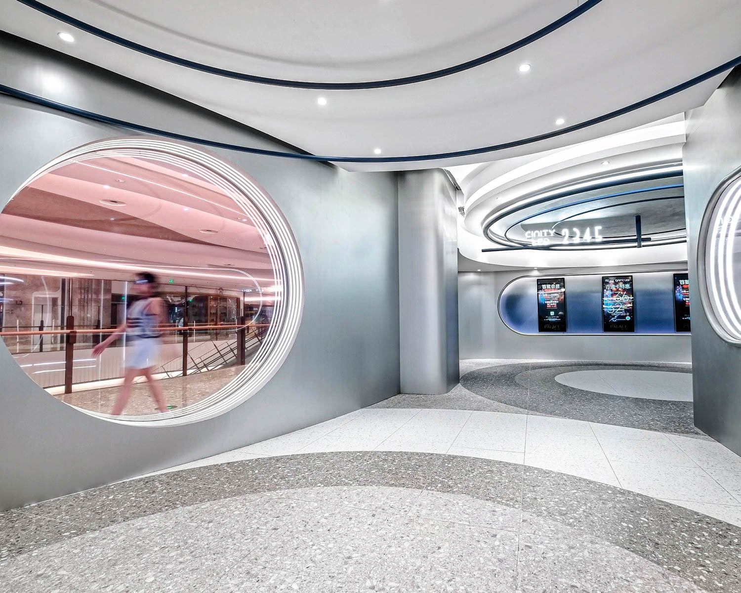 Modern interior of a futuristic cinema lobby with sleek curves and circular windows