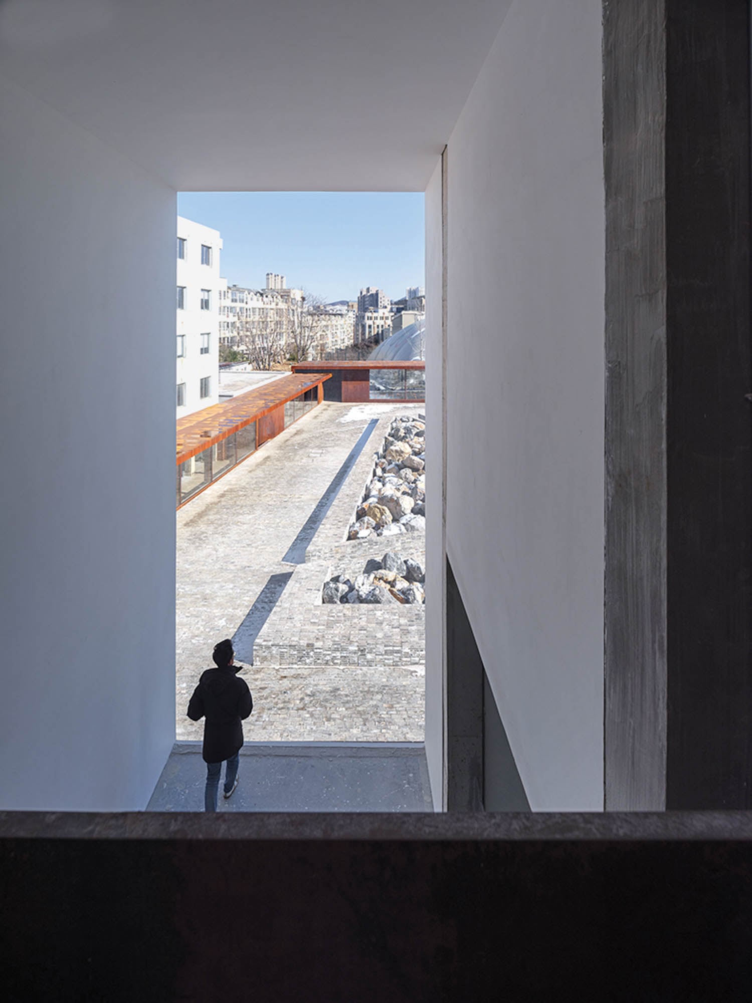 person standing in hallway overlooking city