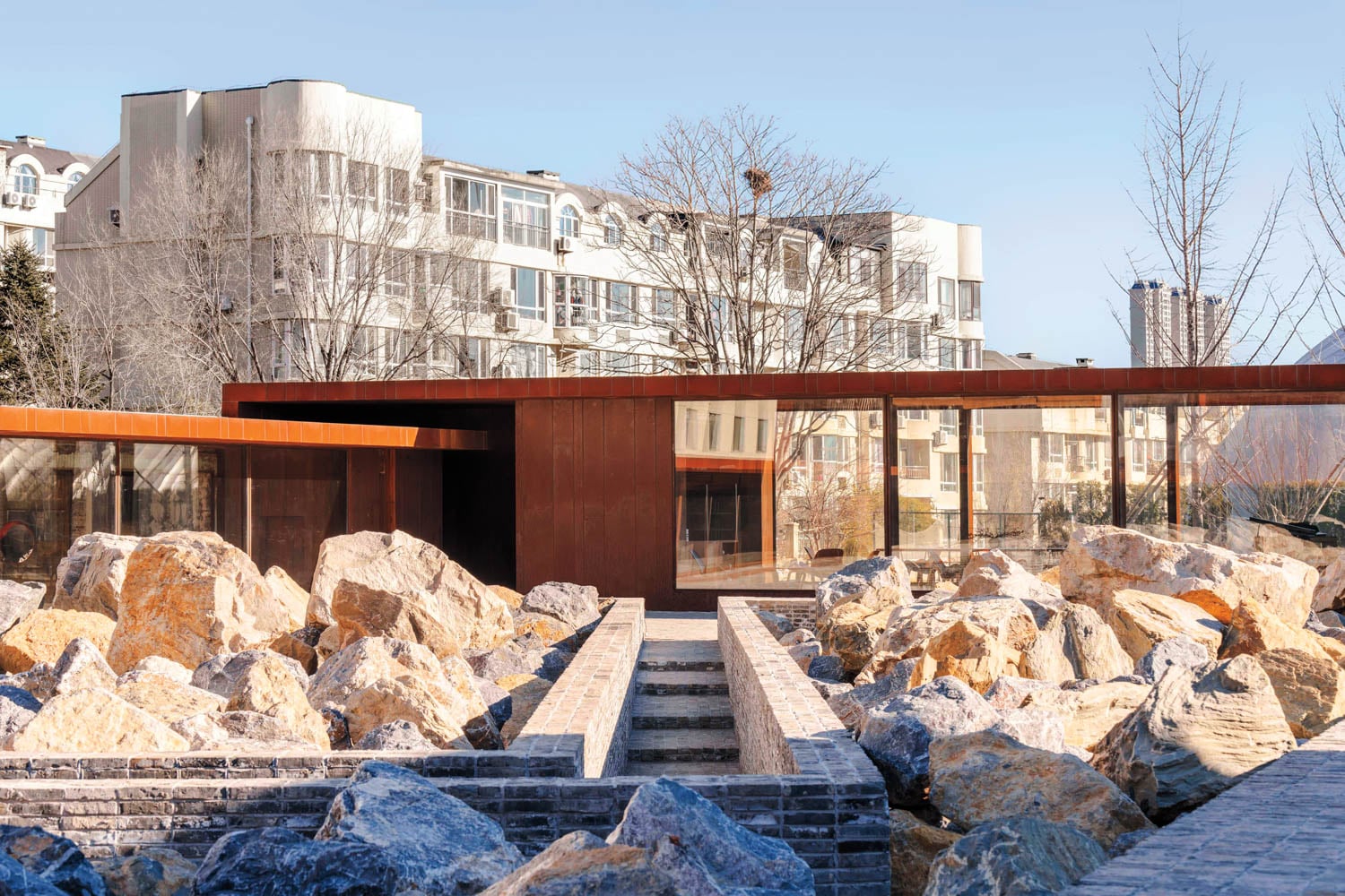 exterior facade of corporate office interior design with lots of rocks and trees