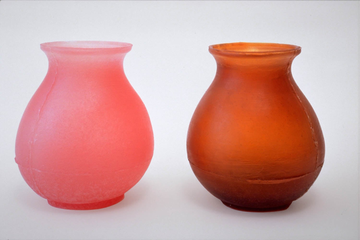 pink and orange urn next to each other