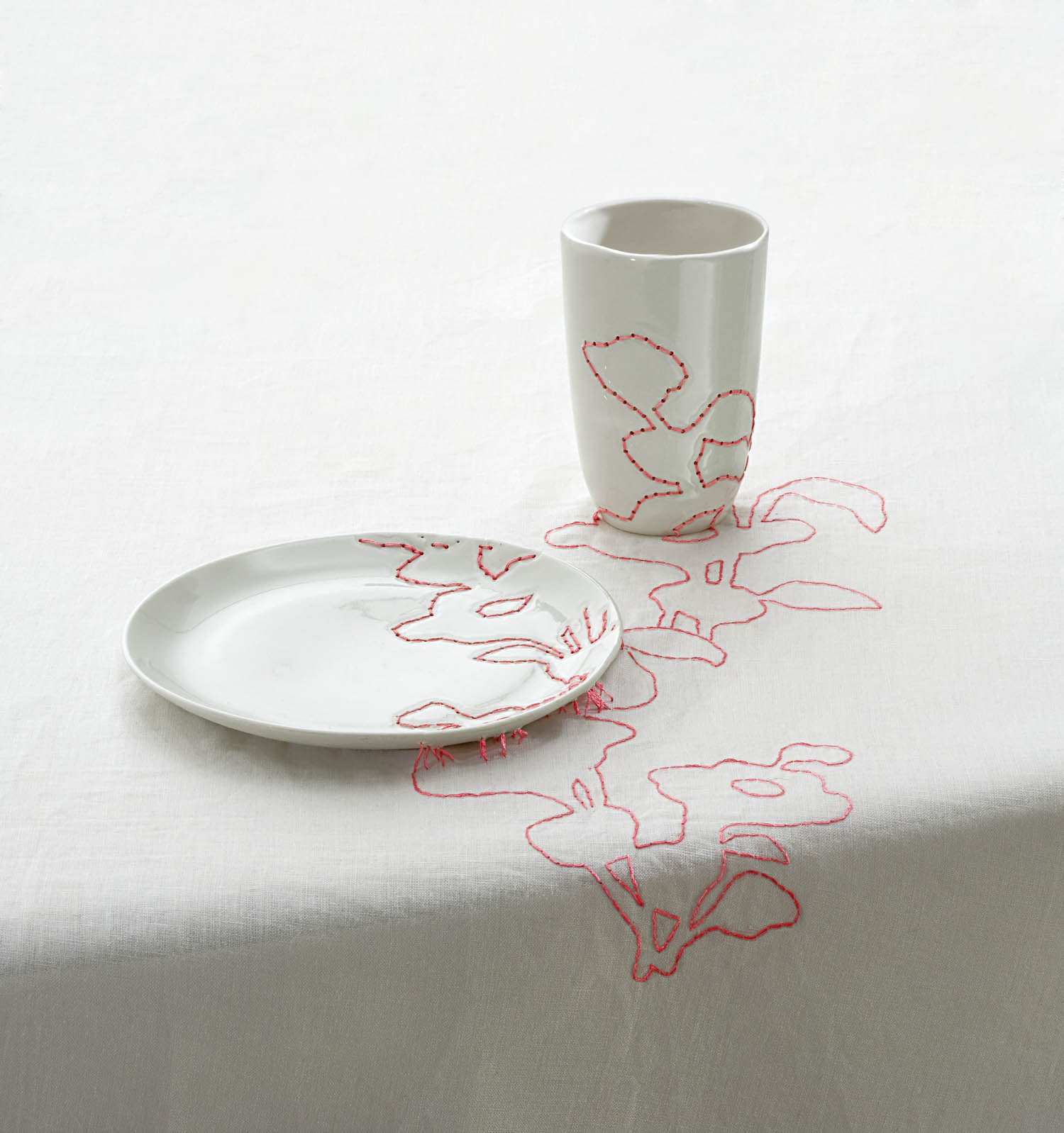 white cup and plate on tablecloth