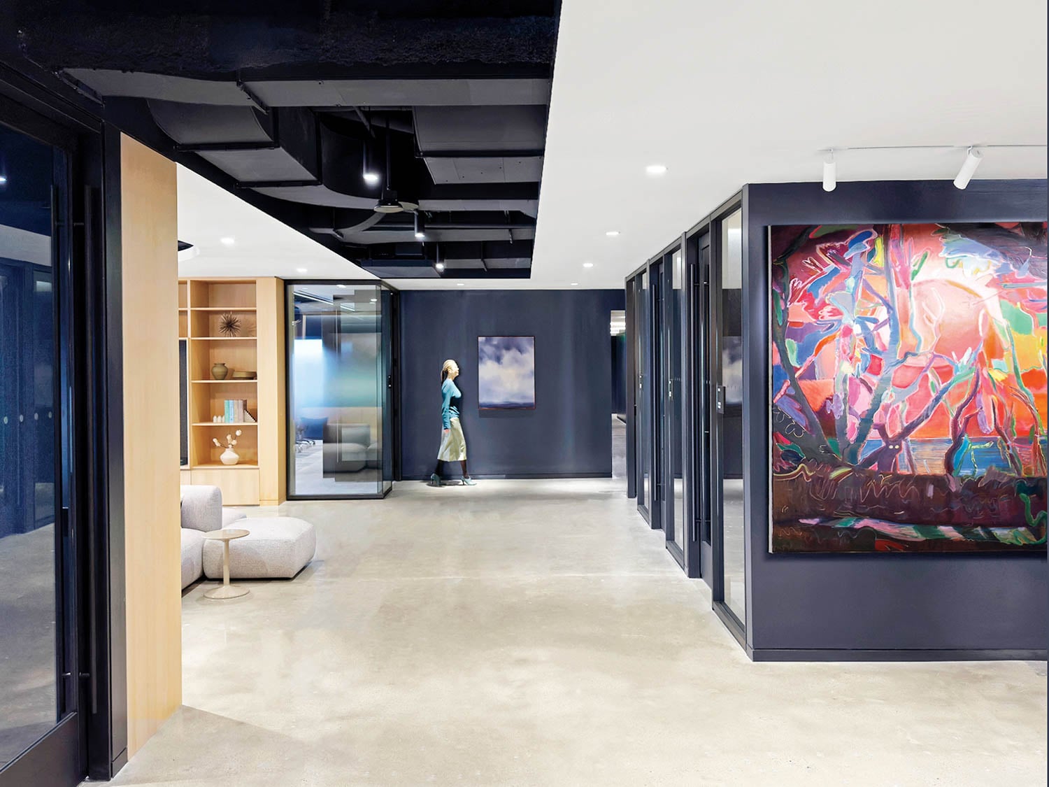 Modern office space with large, vibrant abstract painting on a dark wall