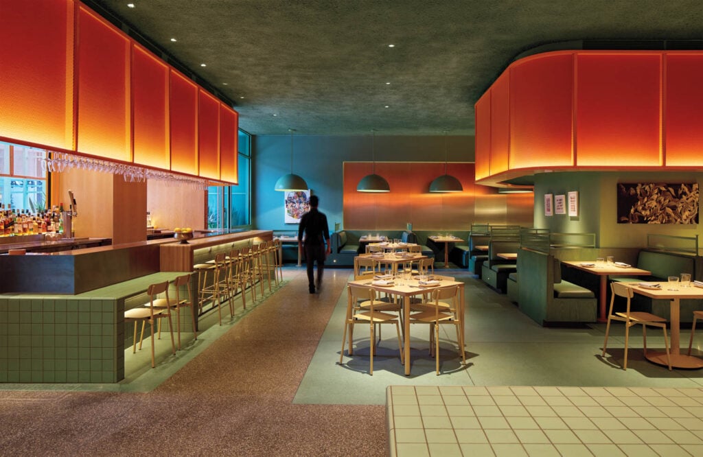 view of dining area with green tables and orange lights