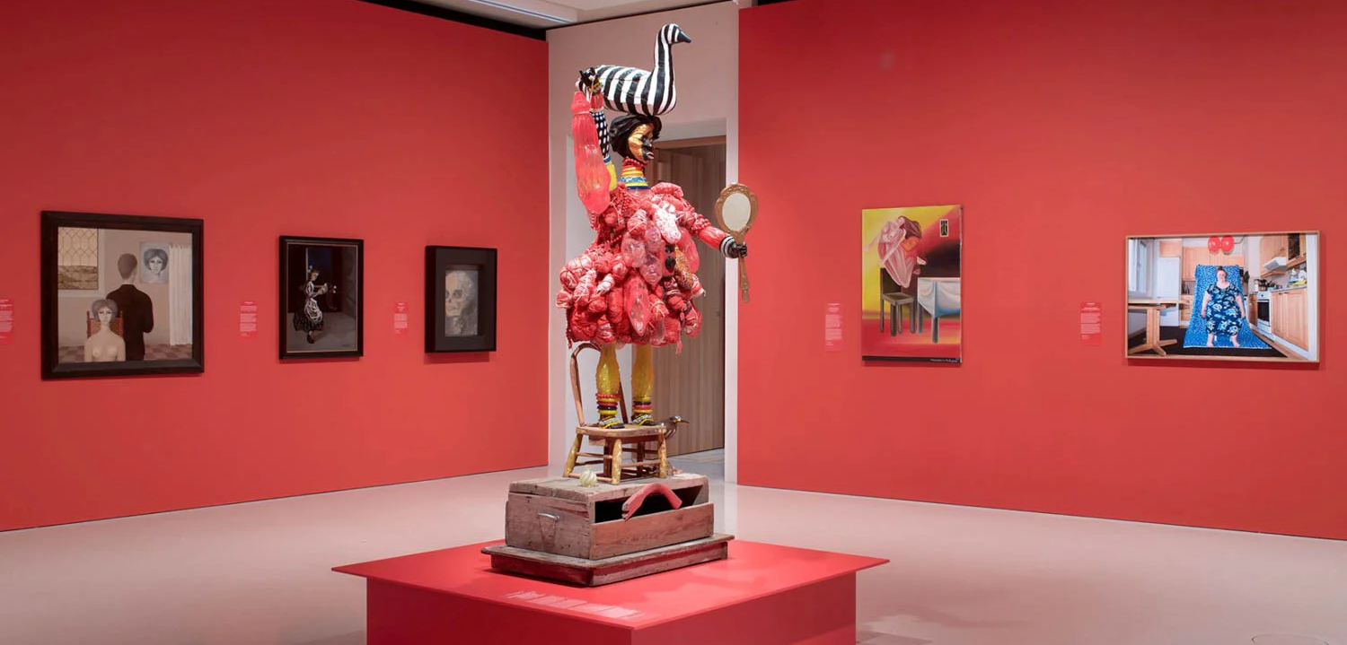 woman in middle of red room with striped bird