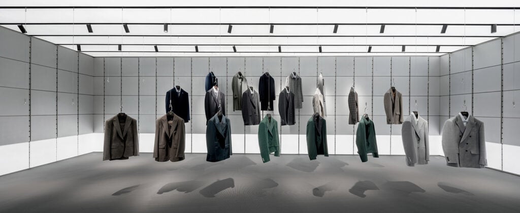 A row of coats hanging in a white room.