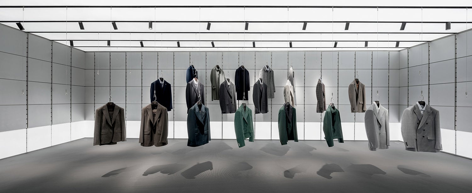 A row of coats hanging in a white room.