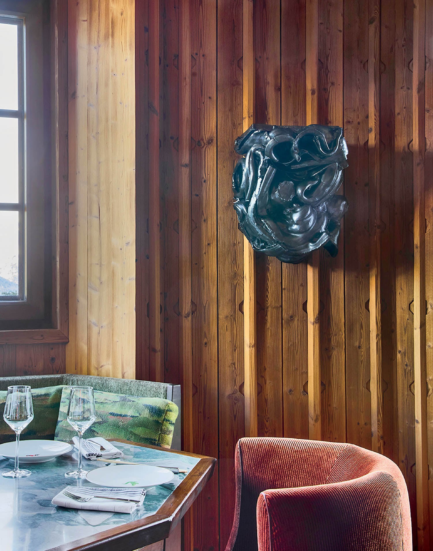 A table with a chair and a vase on it.