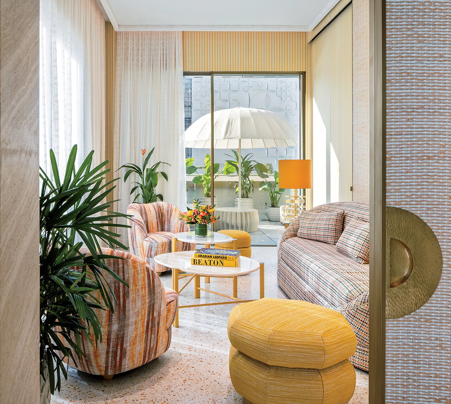 "A living room with a couch, chair, and umbrella"