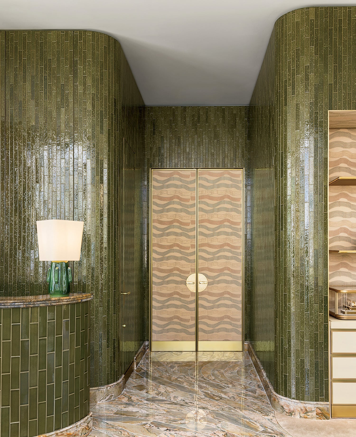 A bathroom with a marble floor and a green wall