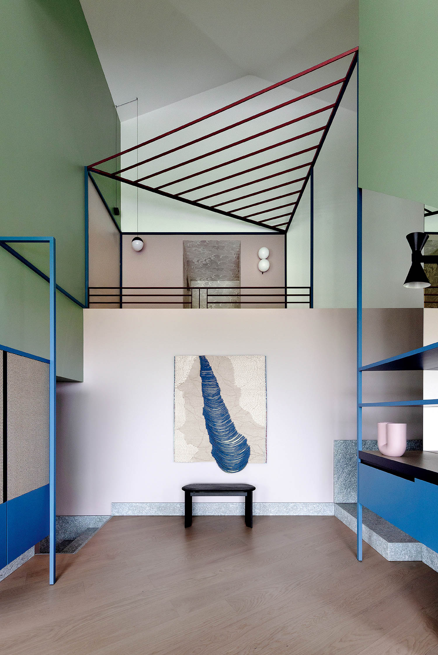 A room with a bed, a table, and a painting.