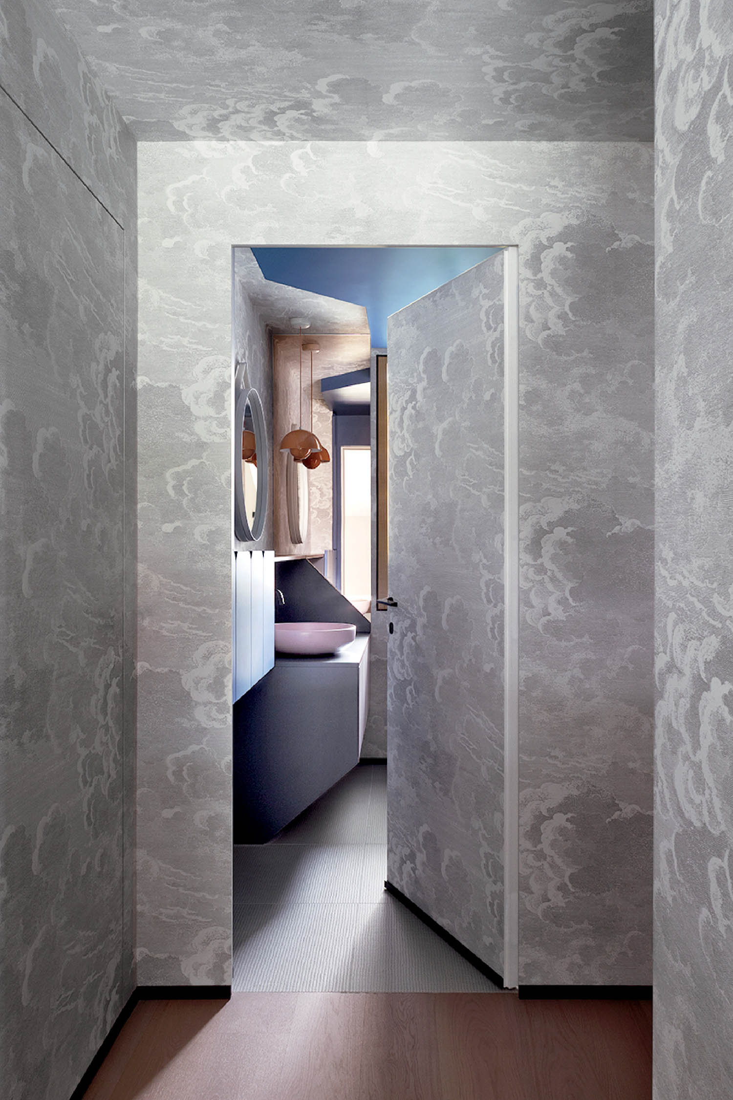 A hallway with a bed and a mirror.