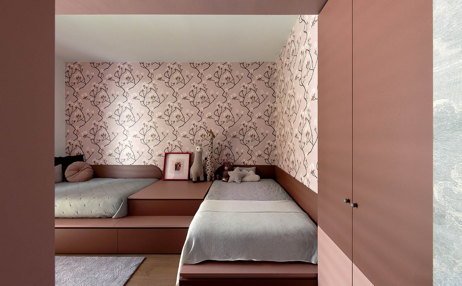 A bedroom with a bed and a pink wallpaper.