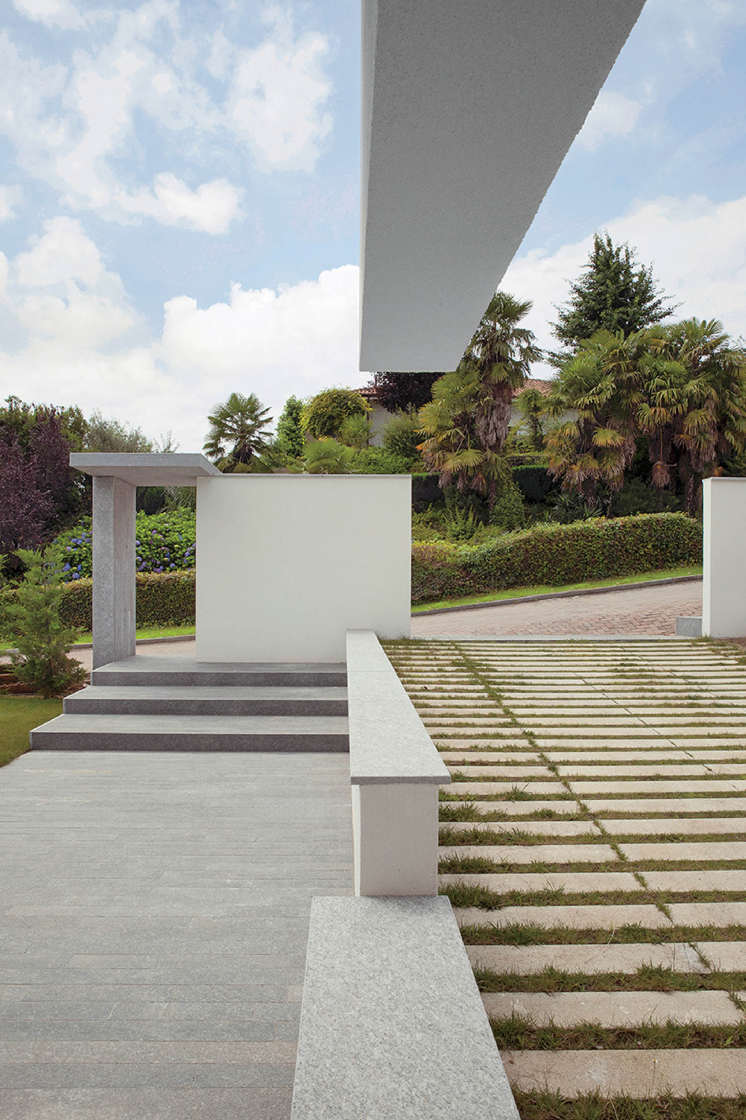 A white bench sitting on a concrete walkway.