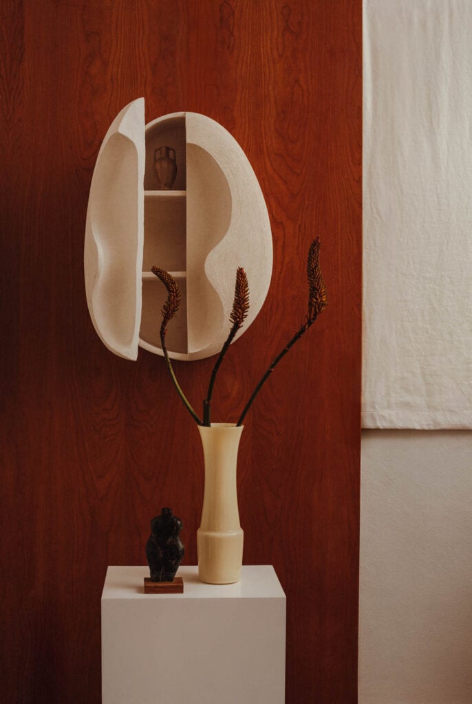 tan vase against red wall