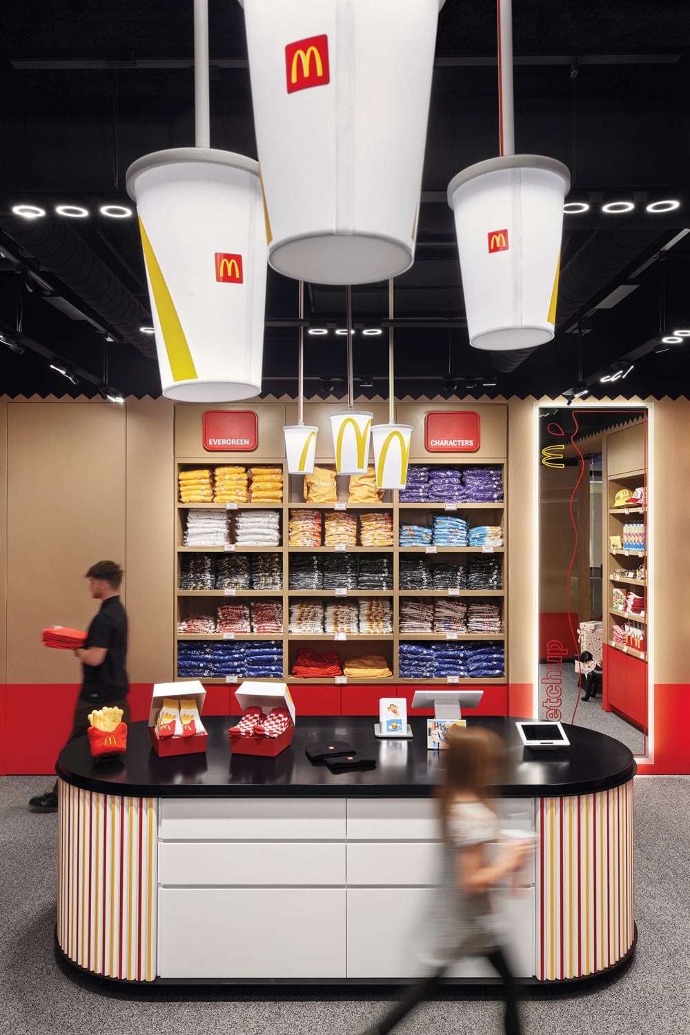 giant mcdonalds cups hang from the ceiling above store counter