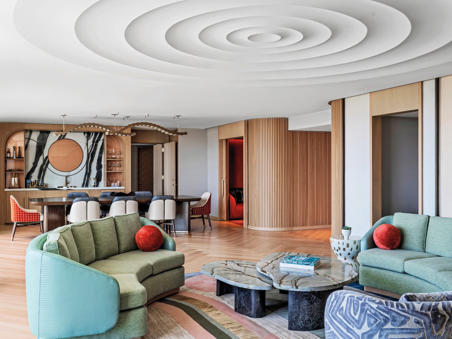 presidential suite with green couches and a designed white ceiling