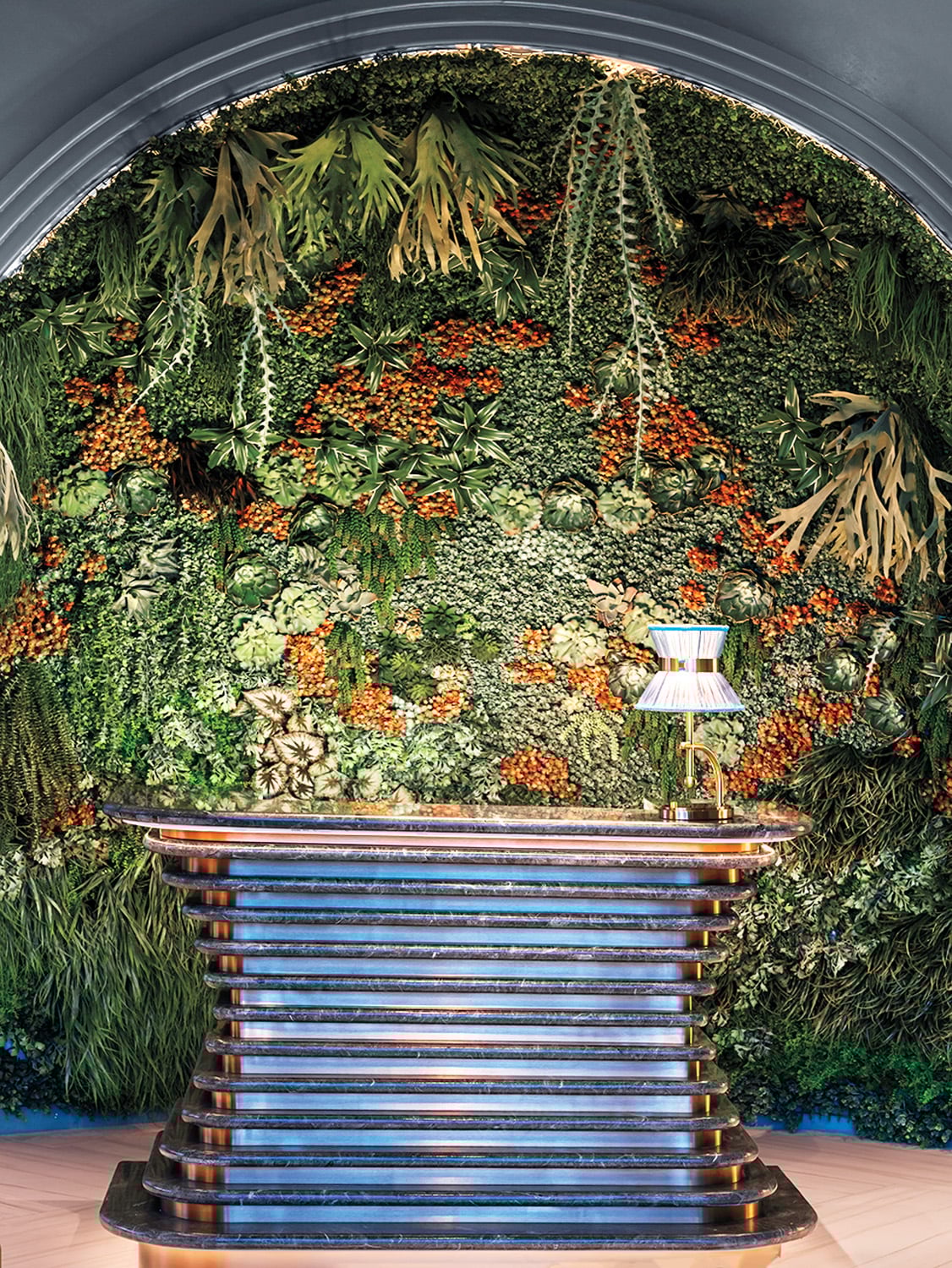 Dried florals backdrop the custom host
stand, faced in Verdi Alpi, at the Garden Room, the members club restaurant.