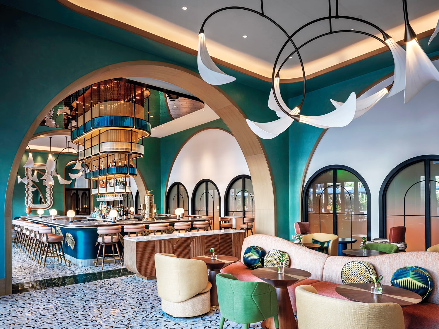 a deep green room with arches and lounge chairs