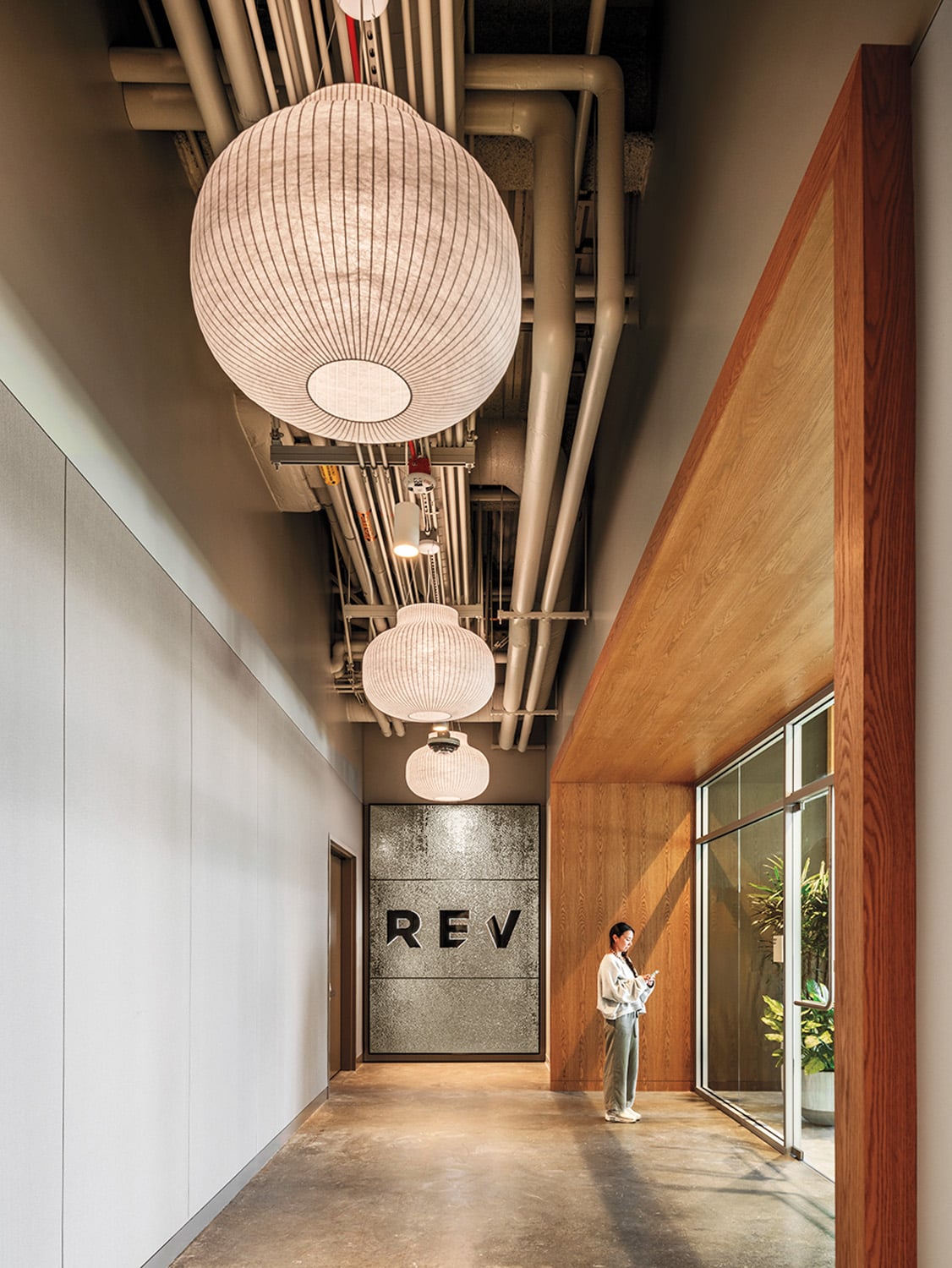 Textured stainless-steel paneling and Benjamin Hubert’s Strand pendants lead to the gym.