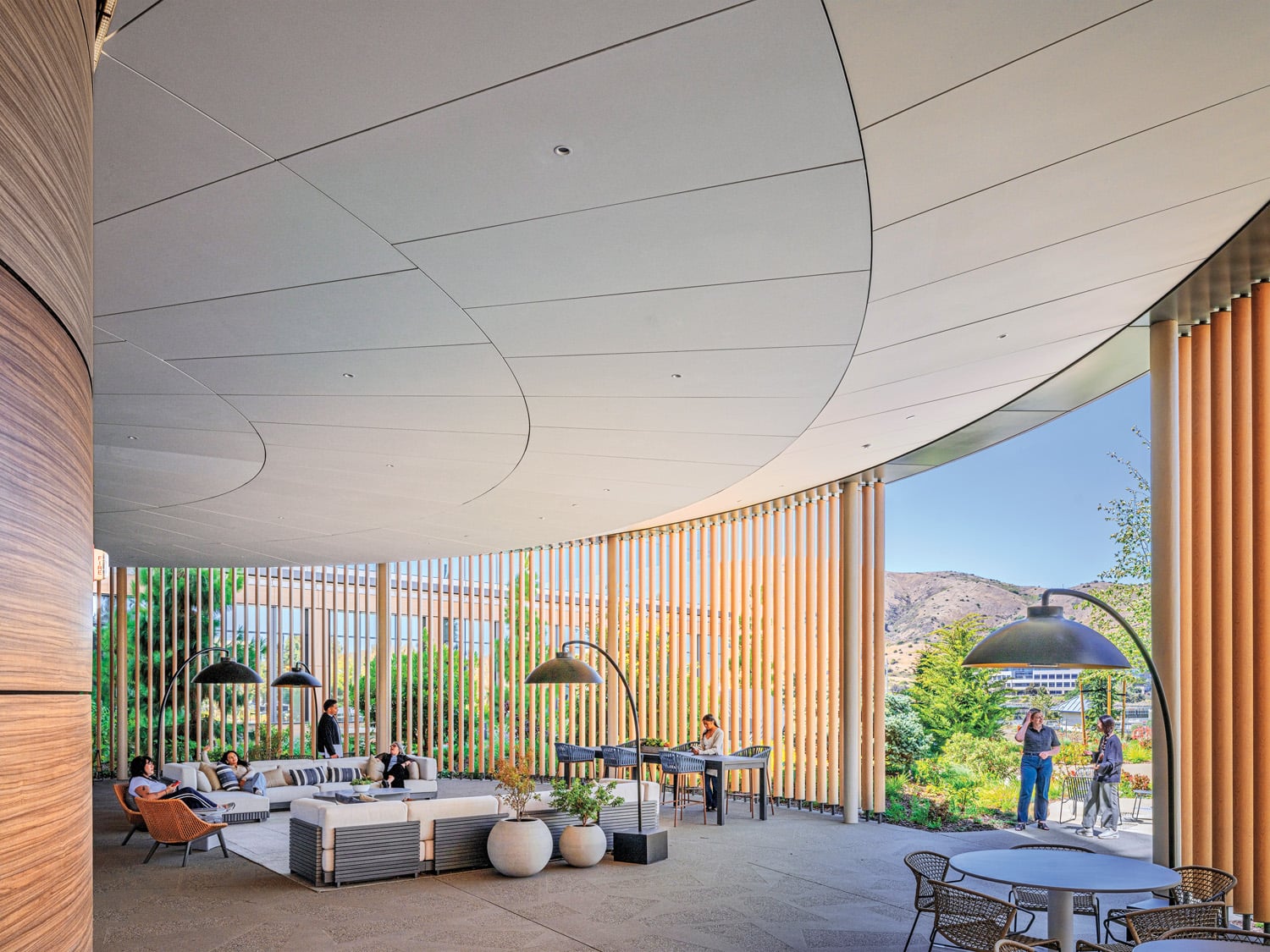 Wood-look aluminum slats screen the conference center patio, furnished with dome heat lamps and Caicos sectionals by Ramón Esteve.