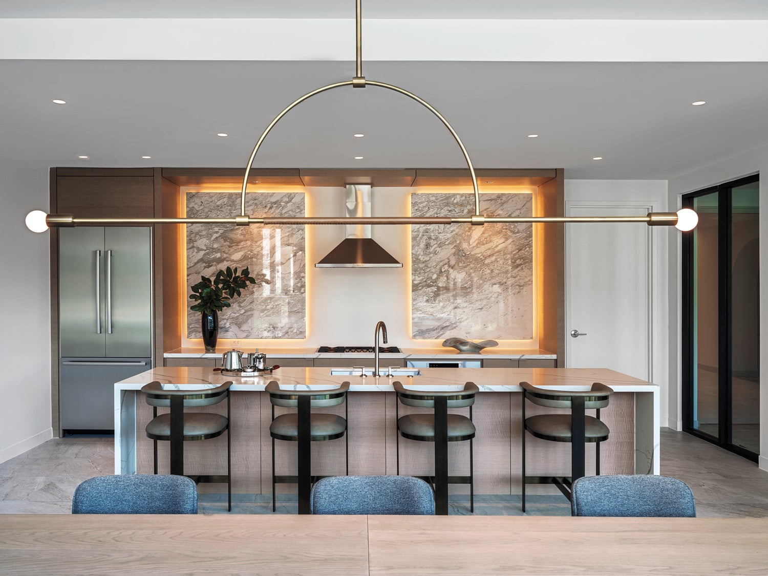 With an open kitchen, the amenity suite’s private dining room includes a custom table and Katy Skelton’s Ellis pendant fixture